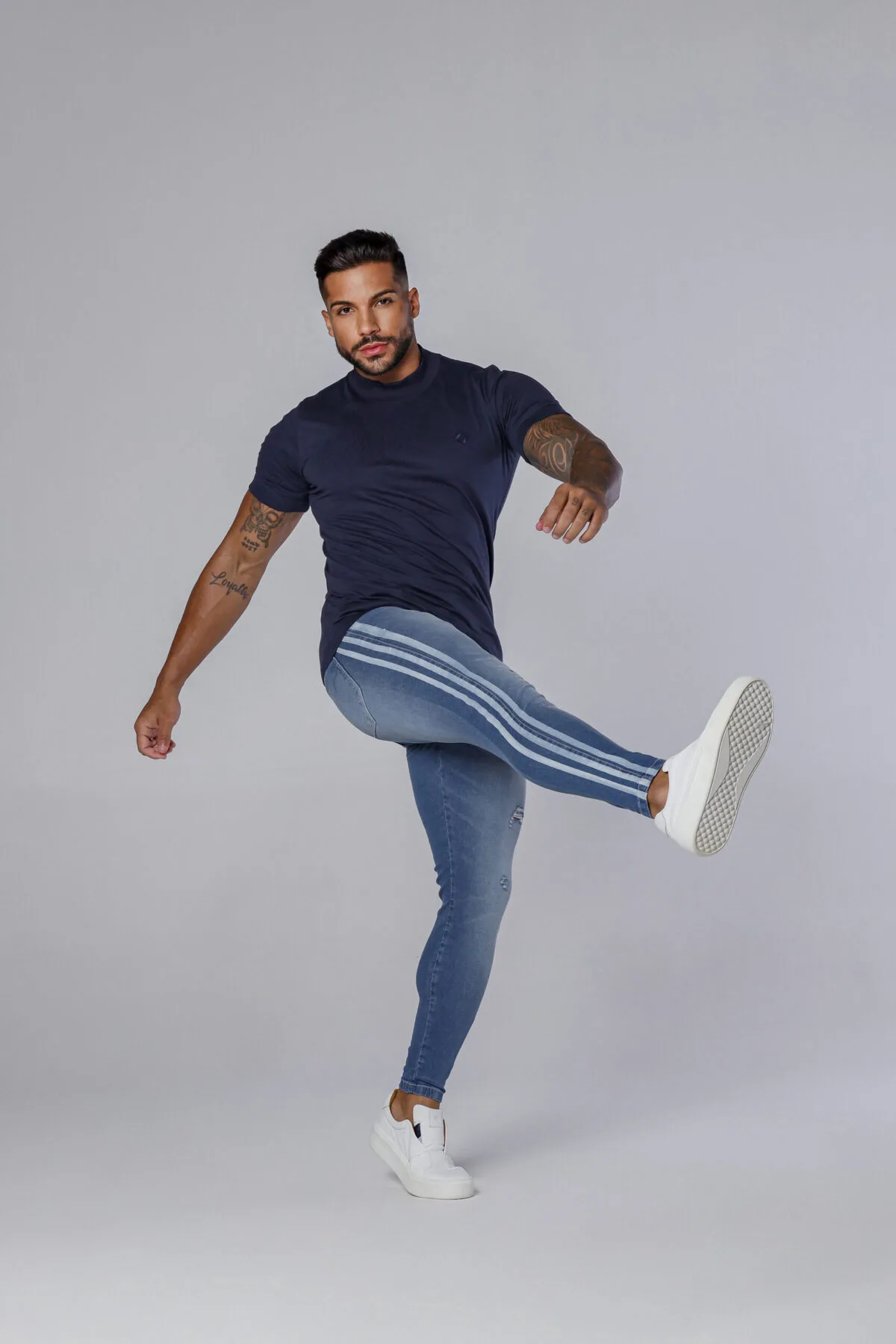 Calça Jeans Azul Com Devorê E Faixas Silkadas Nas Laterais.