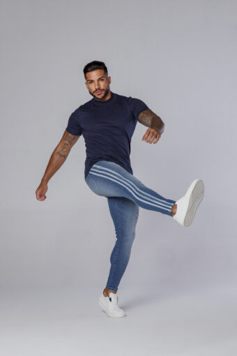 Calça Jeans Azul Com Devorê E Faixas Silkadas Nas Laterais.