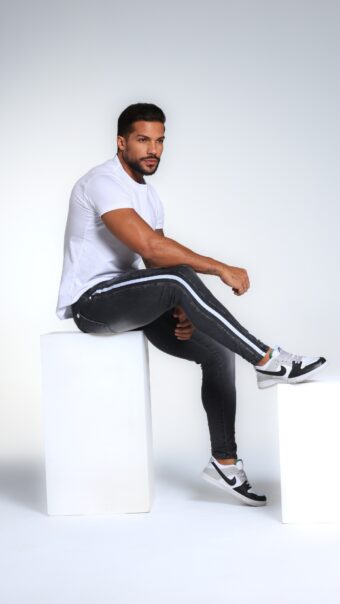 Calça Jeans Escura Com Recortes E Faixas Laterais E Acessórios Brancos.